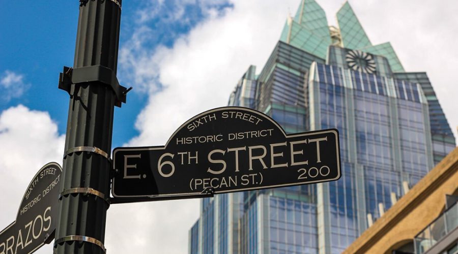 6th street sign in front of the Frost Building in downtown Austin