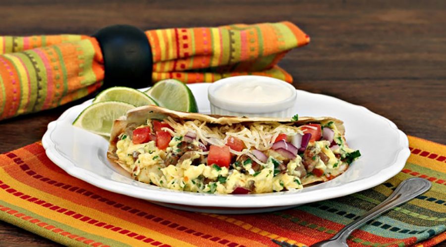 a breakfast taco with limes and sour cream