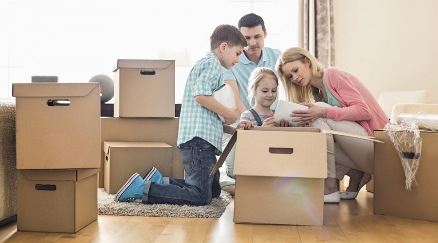 Parents and two young children unpacking boxes