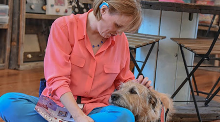 A woman sitting with an emotional support dog