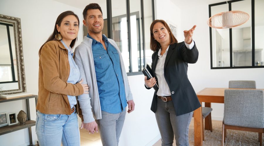 A young couple being shown a home by a Realtor
