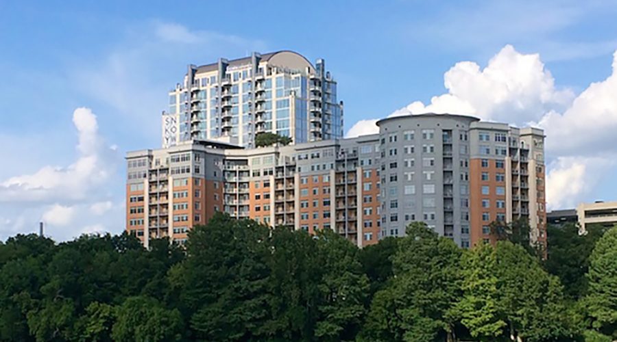 A hilltop condominium complex surrounded by trees